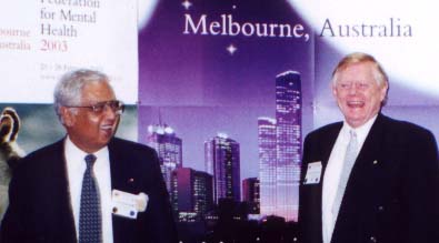 Dr. Chuni Roy (left) head of the Organizing Committee for Vancouver, handing responsibility over to Prof. Graham Burrows, who is in charge of the program for the Melbourne Congress in February 2003.