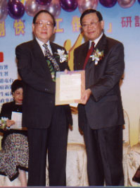 Dr. Raymond Wu (left) presenting an award certificate at the Hong Kong Mental Health Day opening ceremony to Mr. Allen Lee, a local celebrity and entrepreneur who has helped to promote employees' mental health.